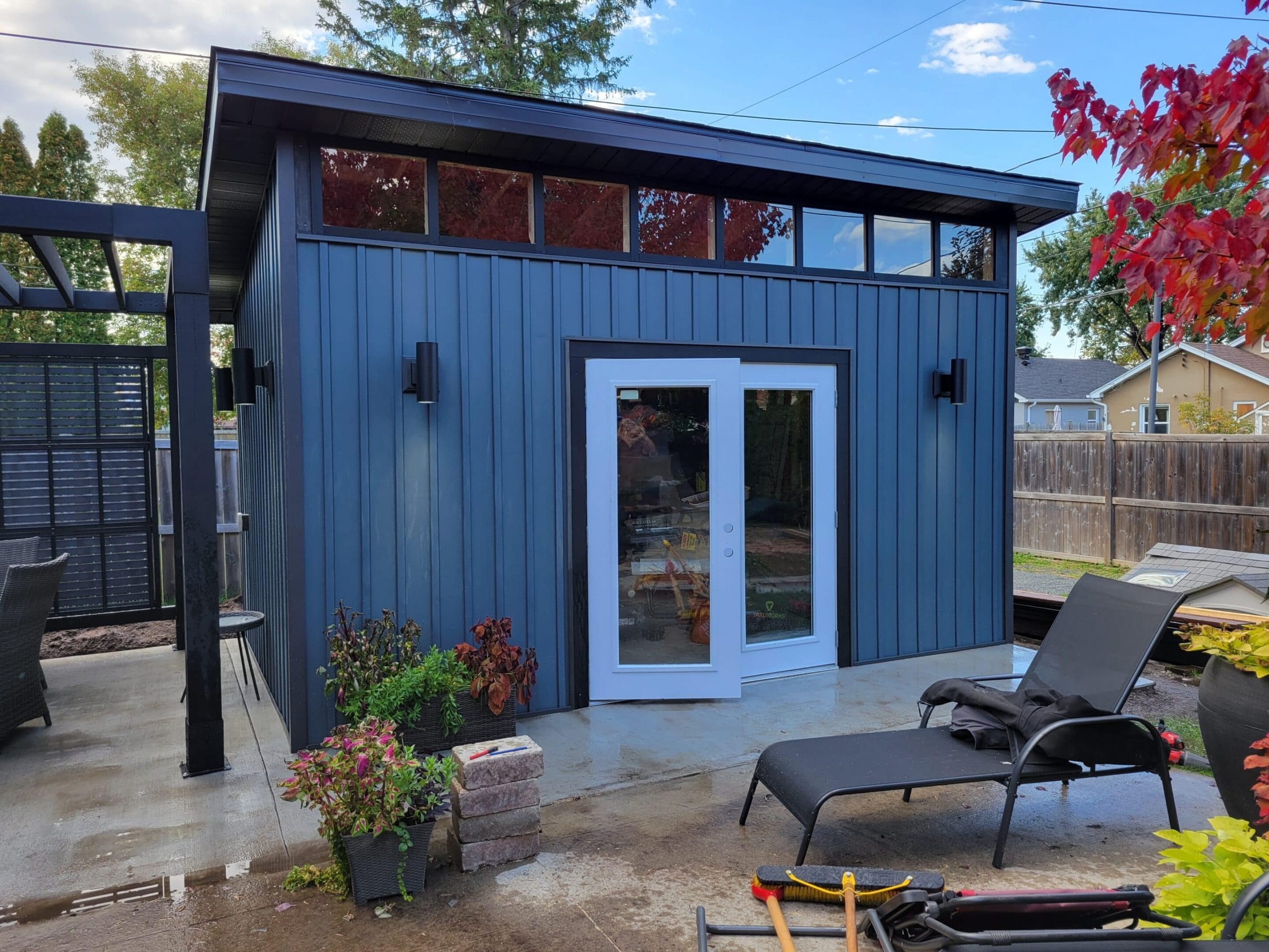 Modern backyard shed with patio seating.
