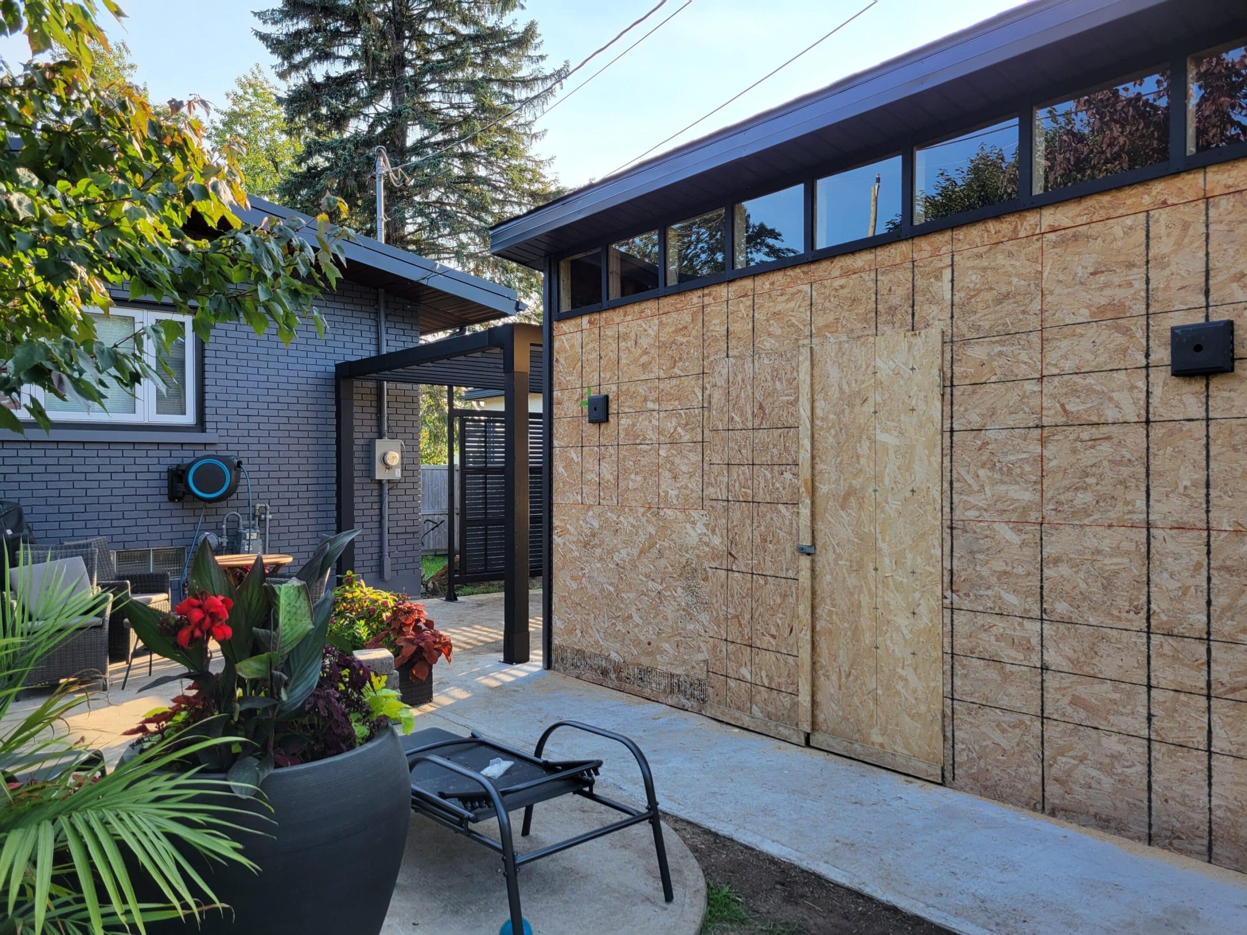 Backyard with unfinished garage and plants.