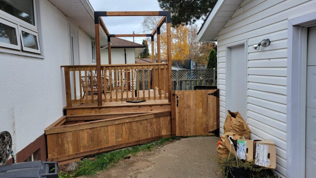 Wooden deck with gate and chairs in yard